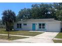 A well-maintained single story home featuring a bright turquoise front door, and a one-car garage at 5417 Postma St, North Port, FL 34287