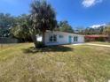 Well kept one-story home featuring new front door, nicely landscaped yard with a palm tree, and a one-car garage at 5417 Postma St, North Port, FL 34287