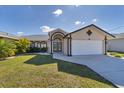 Well-maintained single-story house with a manicured lawn and a paved driveway at 56 Long Meadow Ct, Rotonda West, FL 33947