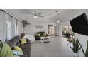 Bright living room with tiled floors, modern decor, and sliding doors to the patio at 56 Long Meadow Ct, Rotonda West, FL 33947