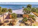 Aerial view showcases waterfront property with private dock, lush landscaping, and stunning water views at 6029 Manasota Key Rd, Englewood, FL 34223