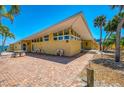 Charming front exterior featuring a unique roofline, brick pathway, and well-maintained landscaping at 6029 Manasota Key Rd, Englewood, FL 34223