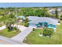 Wide aerial view captures the home's setting with lush landscaping and proximity to local roads at 6062 Spinnaker Blvd, Englewood, FL 34224