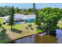 Aerial view of the house, showcasing a screened in pool, large yard, and a serene pond at 6062 Spinnaker Blvd, Englewood, FL 34224
