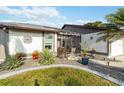 Charming home with lush landscaping, decorative stone accents, and a cozy, screened-in front porch entrance at 667 Foxwood Blvd, Englewood, FL 34223