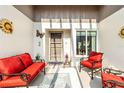 Inviting front porch with comfortable red furniture and nautical decor, perfect for relaxation and enjoying the outdoors at 667 Foxwood Blvd, Englewood, FL 34223