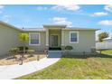 Inviting home exterior with a well-maintained lawn, walkway and colorful plantings leading to the front door at 7089 Benson St, Englewood, FL 34224