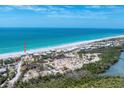Aerial view of the property on a beautiful beach with stunning turquoise waters, and a nearby parking area at 7554 Palm Island S Dr # 1822, Placida, FL 33946