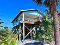 Beautiful coastal home on stilts with an inviting covered porch at 8472 Grand Ave, Placida, FL 33946