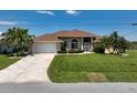 Charming home features a well-kept lawn, double-car garage, and beautiful palms at 9158 Melody Cir, Port Charlotte, FL 33981