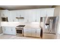 Well-equipped kitchen showcasing stainless steel appliances and sleek white cabinetry at 9853 Bright Water Dr, Englewood, FL 34223