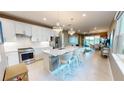 Modern kitchen featuring stainless steel appliances, granite countertops, and a spacious island with seating at 9853 Bright Water Dr, Englewood, FL 34223