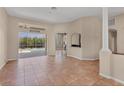 Spacious living room featuring neutral walls, tile flooring, and sliding glass doors to the outdoor area at 10495 Atenia St, Port Charlotte, FL 33981