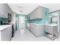Modern kitchen with gray cabinetry, stainless steel appliances, and plenty of counter space, offering a clean and functional design at 1245 Gulf Blvd, Englewood, FL 34223