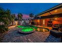 Backyard pool area with a hot tub, patio, and lush landscaping; perfect for outdoor entertaining and relaxation at 1245 Gulf Blvd, Englewood, FL 34223