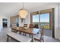 Elegant dining room featuring stylish chandelier, wood table, and sliding doors to the balcony at 13113 Gasparilla Rd # A503, Placida, FL 33946