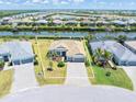 Waterfront home featuring a paver driveway, two car garage, and lush landscaping at 14556 Gaspar Loop, Port Charlotte, FL 33981