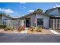 Charming single-story home featuring a lovely garden, a wooden fence, and an American flag at 148 Jose Gaspar Dr # 148, Englewood, FL 34223