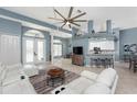 Inviting living room featuring tile floors, a modern ceiling fan, and an open layout leading to the kitchen at 15674 Applewhite Cir, Port Charlotte, FL 33981