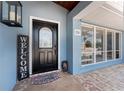 Up close view of the front door, with beautiful walkway, welcome sign, and blue exterior at 158 Morgan Se Ln, Port Charlotte, FL 33952