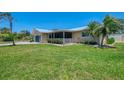 Exterior side view of the house showing the spacious, well-maintained lawn and screened-in porch at 1585 Poinciana Rd, Venice, FL 34293