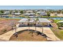 Elevated view of a well-manicured property with a home, driveway, and nearby canal at 1915 Illinois Ave, Englewood, FL 34224
