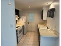 Efficient kitchen featuring white appliances, tile floor, and contrasting black and white cabinets at 194 Garden Nw Ave, Port Charlotte, FL 33952