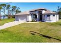 Charming single-Gathering home featuring a well-manicured lawn, three-car garage, and an inviting entrance at 27 Tee View Rd, Rotonda West, FL 33947