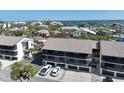 Condo building with screened balconies, two floors, and ground-level garages at 2769 N Beach Rd # 205, Englewood, FL 34223