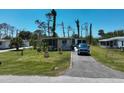 Quaint single-story home with well-manicured lawn and flowering plants at 2906 Waterside Dr, Englewood, FL 34224