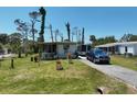 Inviting single-story home with a well-kept lawn, a blue truck and flowering plants at 2906 Waterside Dr, Englewood, FL 34224