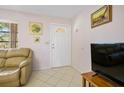 The entryway offers neutral tile flooring, light pink walls, and a convenient coat closet at 3189 Siesta Dr, Venice, FL 34293
