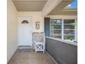 Inviting front porch with decorative tile flooring, a window and a charming welcome mat at 3189 Siesta Dr, Venice, FL 34293