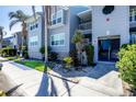 Condo exterior with lush tropical landscaping in front of a charming two-story building at 4410 Warren Ave # 306, Port Charlotte, FL 33953