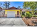 Charming home featuring a white garage door, bright exterior, and well-manicured landscaping at 521 Artists Ave, Englewood, FL 34223