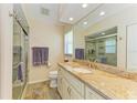 Bathroom with a granite-topped vanity, tiled floor, and glass-enclosed shower at 68 Long Meadow Ln, Rotonda West, FL 33947