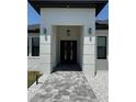 Inviting front entrance with a paved walkway and contemporary black double doors at 725 Clearview Dr, Port Charlotte, FL 33953