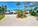 Beautiful home featuring a circular driveway, tropical landscaping, and ample parking at 760 S Oxford Dr, Englewood, FL 34223