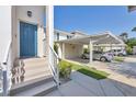 Inviting front entrance with a blue door and covered carport providing convenient parking at 821 Montrose Dr # 201, Venice, FL 34293