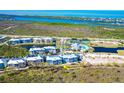 Beautiful aerial view of a condo complex near intercoastal with a pond, a pool, and tennis courts at 8413 Placida Rd # 205, Placida, FL 33946