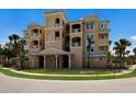 Multi-story condo building with private balconies and tropical landscaping at 8500 Amberjack Cir # 102, Englewood, FL 34224