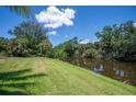 Green backyard area with waterfront views, providing a tranquil outdoor space at 10182 Charlemont Ave, Englewood, FL 34224