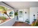 Charming front porch with brick flooring and decorative plants creating a welcoming entrance at 10182 Charlemont Ave, Englewood, FL 34224