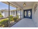 Welcoming screened entryway with double doors and decorative light fixture at 1035 Riggs St, Port Charlotte, FL 33952