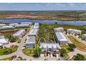 Aerial view of townhouse in a waterfront community near a pond, landscaping, and winding roads at 10411 Coral Landings Ln # 85, Placida, FL 33946