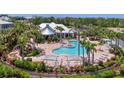 Community pool featuring lush landscaping, lounge chairs, and shade for relaxing in the sun at 10411 Coral Landings Ln # 85, Placida, FL 33946