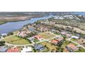 Wide aerial shot of a residential neighborhood with a river and green spaces nearby at 11 Amberjack Ln, Placida, FL 33946