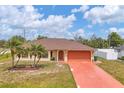 Inviting one-story home with palm trees, a terracotta driveway, and lush lawn at 11008 Waterford Ave, Englewood, FL 34224