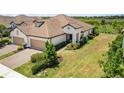 Sprawling single-story home with a tile roof, two-car garage, and lush green landscaping at 11125 Mcdermott Ct, Englewood, FL 34223