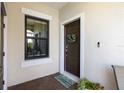 Welcoming front entry with a decorative wreath and a charming welcome mat at 11125 Mcdermott Ct, Englewood, FL 34223